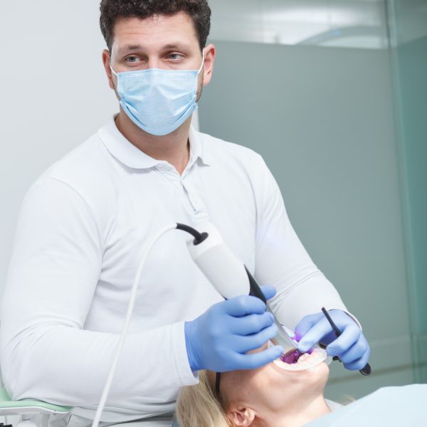 Dentiste réalisant une empreinte numérique avec un scanner dans un cabinet dentaire