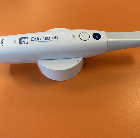 Scanner d'empreinte numérique Medit i700 avec le logo du laboratoire de prothèses dentaires Odontolab posé dessus